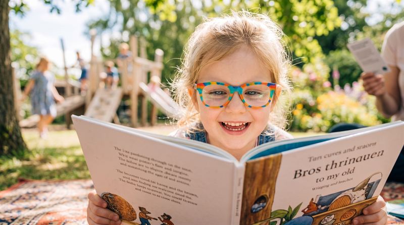A young boy or girl smiling outdoors in Stockport, representing clear, active vision under a myopia management programme.